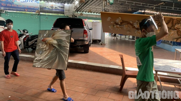 Khuân, dọn các bức tranh treo tại các phòng trong một nhà hàng.