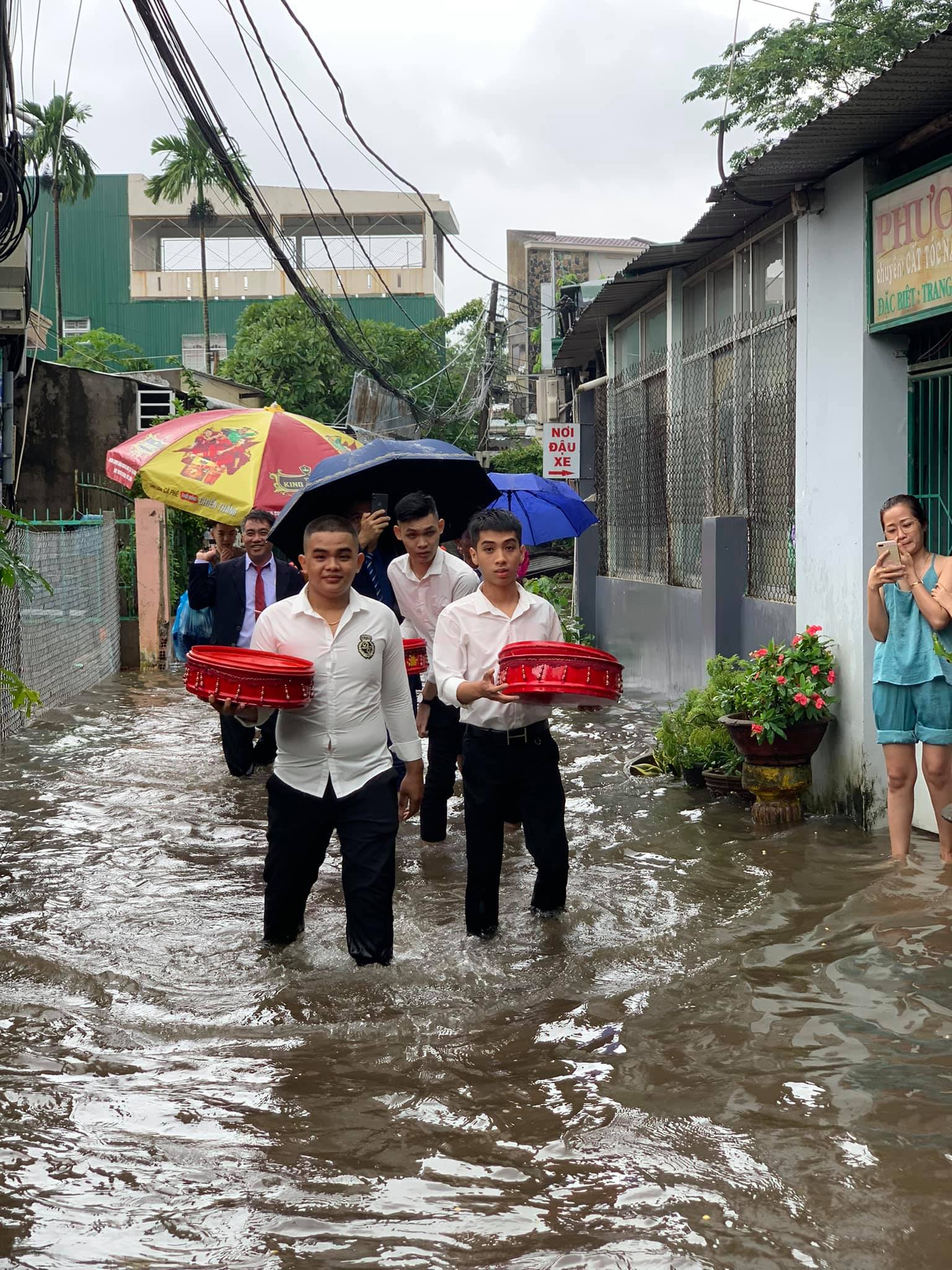 Đoàn bê tráp và người thân của cô dâu chú rể dù phải bì bõm lội nước nhưng ai nấy đều rất vui vẻ. 