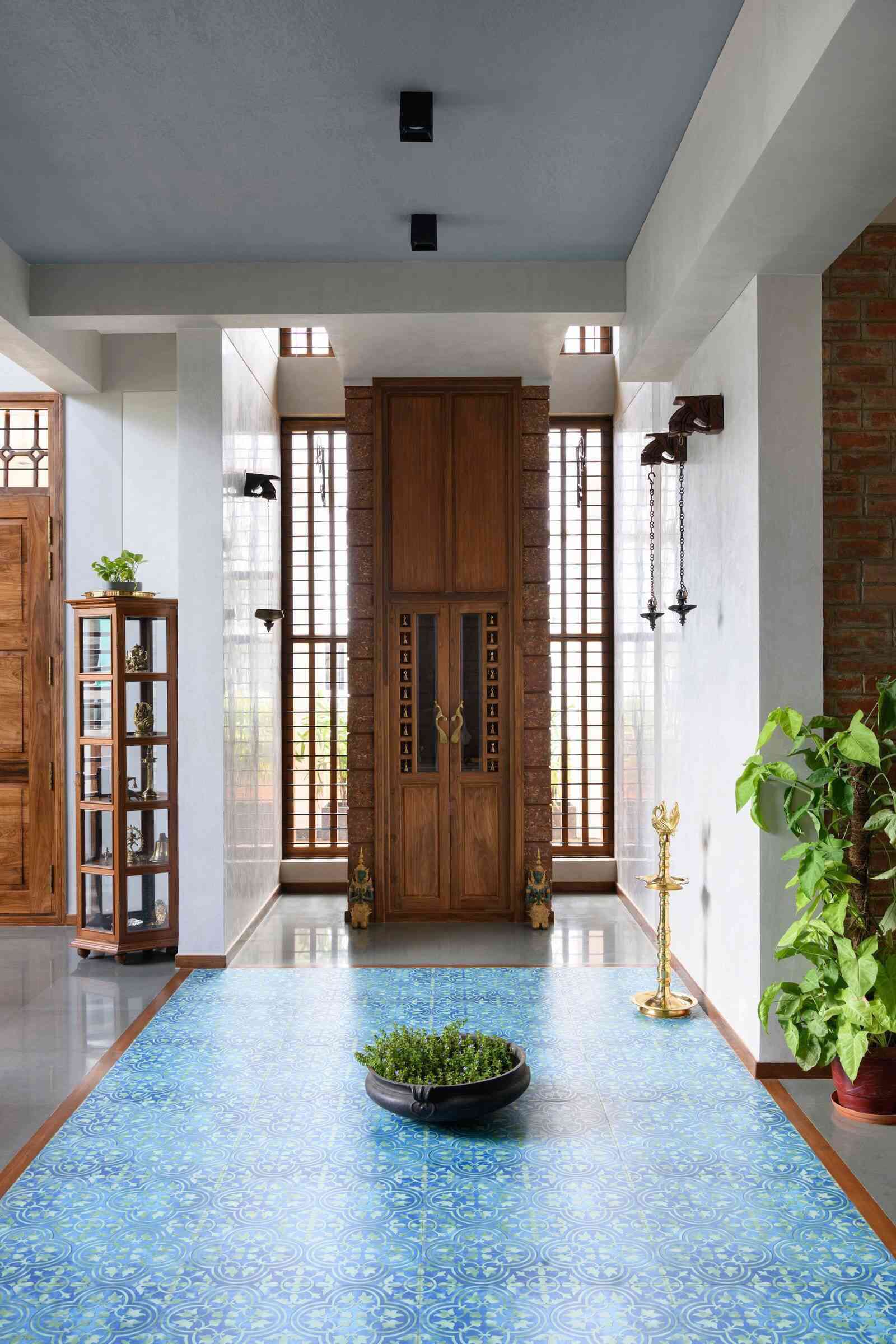 Phần cửa lớn được chạm khắc tinh xảo ở ngay lối vào kết hợp với phần sàn xanh ngọc giúp tạo ấn tượng mạnh cho khách khi đến nhà.
