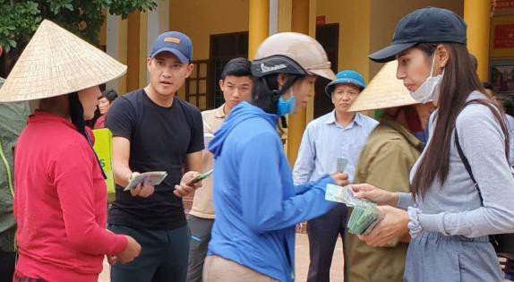 Ca sĩ Thủy Tiên trao tiền hỗ trợ cho người dân bị ảnh hưởng bởi lũ lụt.