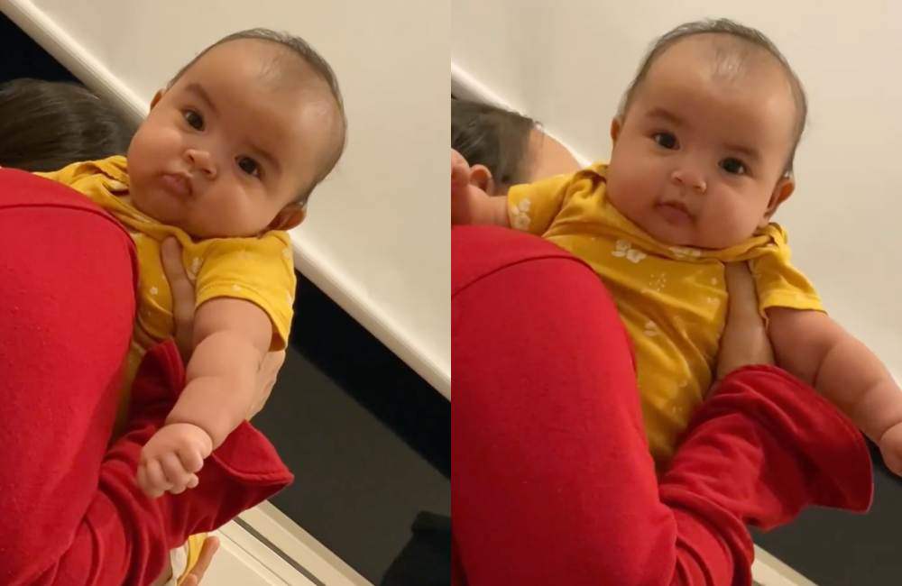 Sau khi được bế, bé Moon liền trở lại gương mặt vui vẻ, hóng chuyện với mẹ.