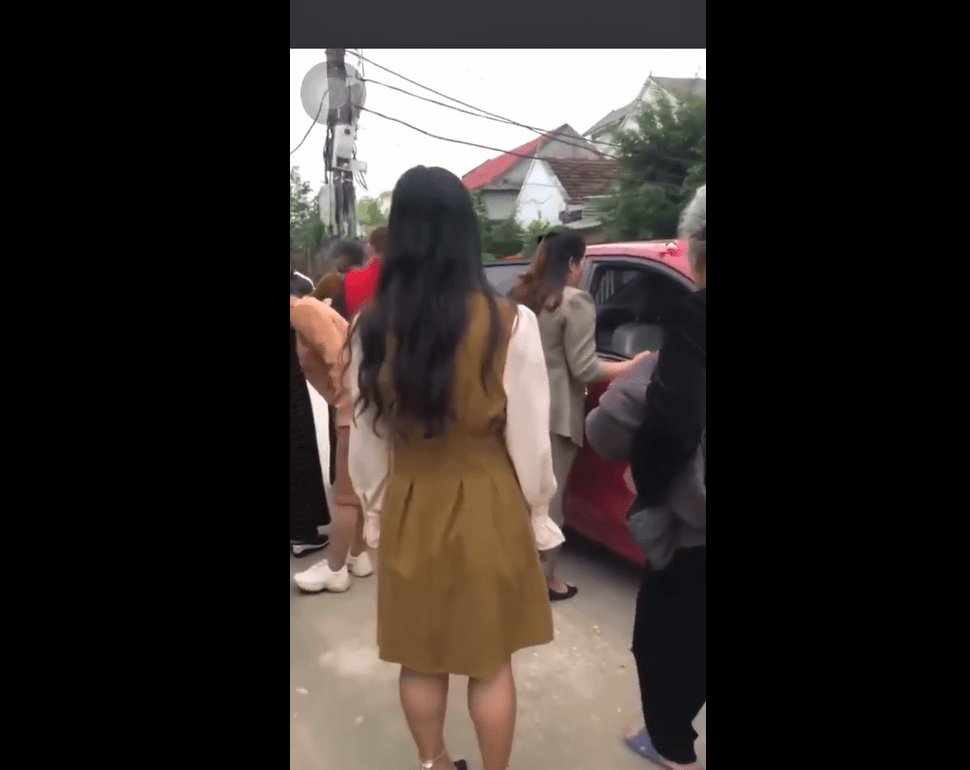 Người thân, bạn bè vây quanh xe chở cô dâu đi đẻ