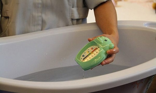 Đo nhiệt độ nước tắm cho trẻ sơ sinh bằng nhiệt kế.(Ảnh minh họa)