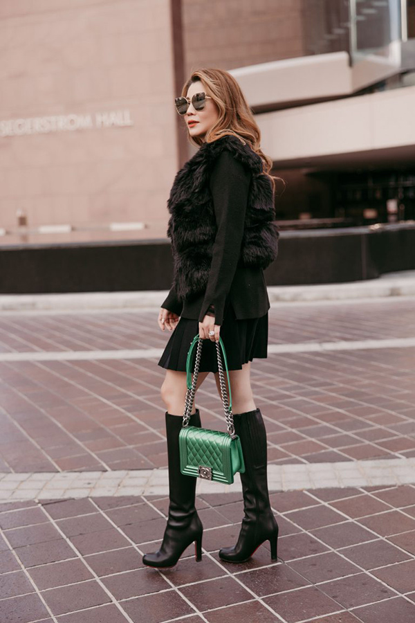 Nữ doanh nhân chứng minh gu thẩm mỹ và khả năng phối đồ nổi bật. Cô tinh tế mix kèm set váy đen, gile lông và chiếc túi hàng hiệu màu xanh độc đáo, mắt kính thời trang sành điệu.
