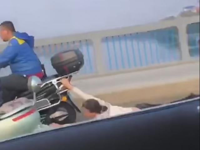 Sự thật sau hình ảnh vợ bám đuôi xe máy chồng, bị kéo lê trên đường rách toạc quần áo