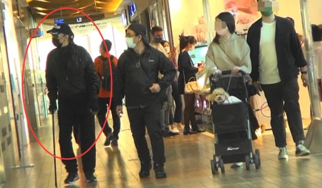 Ông phải chống gậy để đi lại.