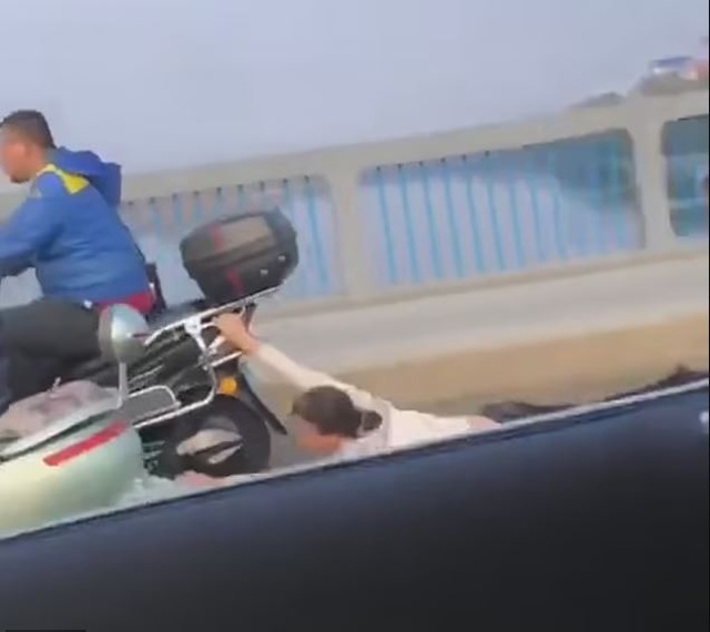 Sự thật sau hình ảnh vợ bám đuôi xe máy chồng, bị kéo lê trên đường rách toạc quần áo - 1