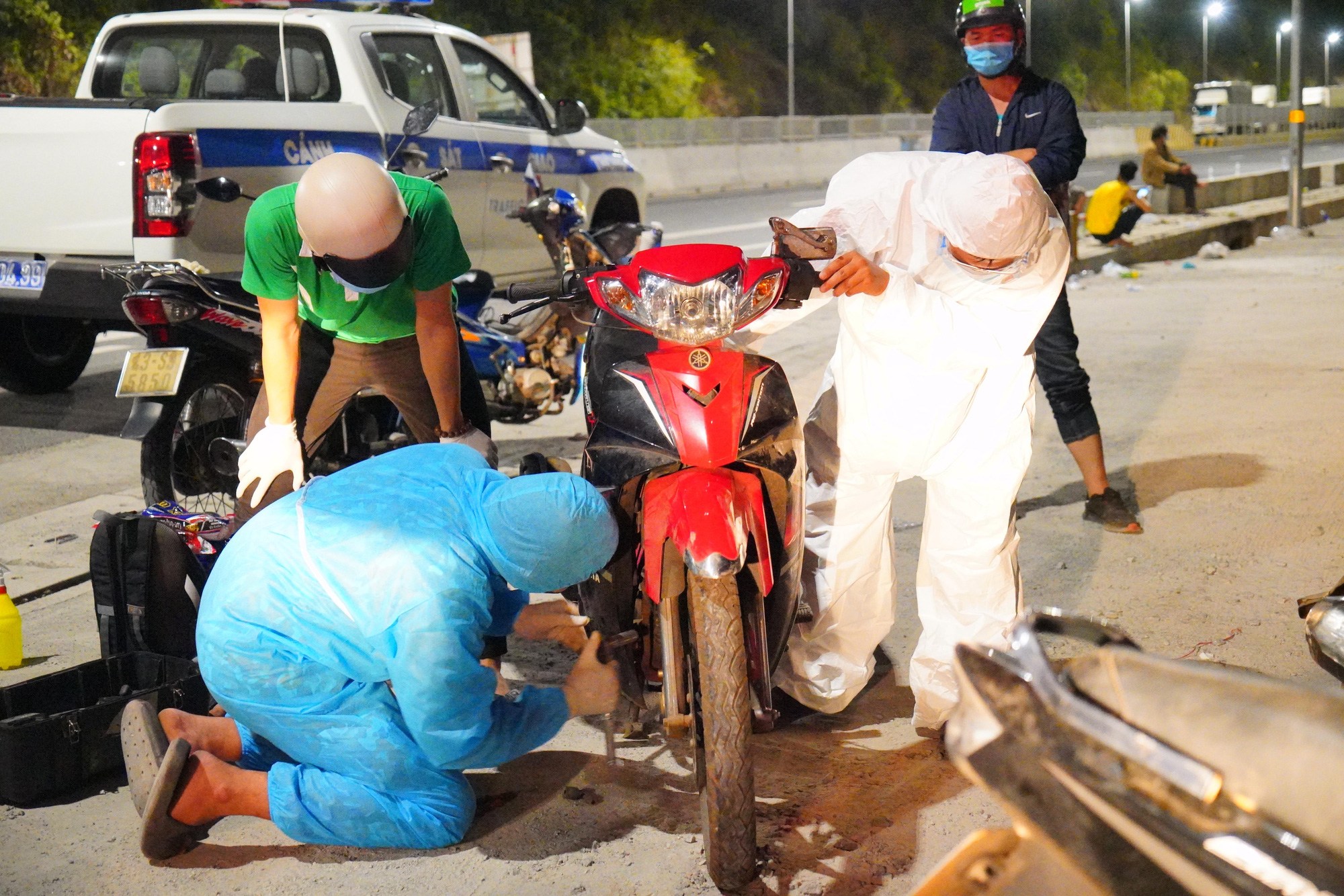 Một số tình nguyện đang sửa chữa xe cho người hồi hương từ thành phố về quê sau dịch