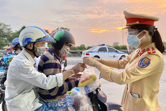 Cảnh sát giao thông tặng đồ ăn cho người dân trên đường
