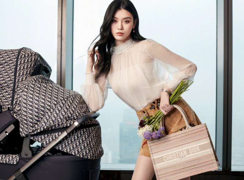 Bức ảnh đậm chất mẹ bỉm sữa của Hề Mộng Dao. Dù vậy, vẫn có thể phát hiện ra độ chịu chơi của bà mẹ 2 con. Có thể thấy, Hề Mộng Dao xách chiếc túi Christian Dior xa xỉ. Đó là mẫu túi Dior book tote in multicolor stripe có giá trên dưới 100 triệu VNĐ. Sốc hơn, chiếc xe đẩy trong có vẻ bỉm sữa như thế nhưng có giá dao động từ 135 - 210 triệu VNĐ tuỳ dòng. 