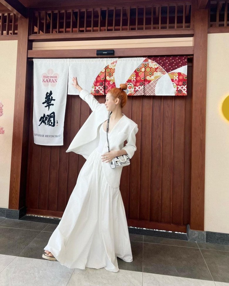 Chiếc đầm trắng chấm gót mix cùng áo blazer trắng đẹp tuyệt. Cô trưng diện combo này cho những ngày dạo phố chơi ở Đà Nẵng. Một chiếc túi xách hiệu Christian Dior chính là thứ nâng tầm phong cách.