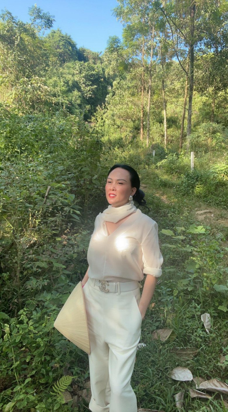 Đến một outfit khác, Phượng Chanel lại trắng xoá với set đồ sang xịn tới từ Chanel. Mấy ai đi rừng làm nông mà lại diện tông màu đậm chất tiểu thư, quý tộc như vậy? Cô còn không quên tô điểm cho vẻ ngoài của mình với bông tai, khăn quấn cổ rất trendy.