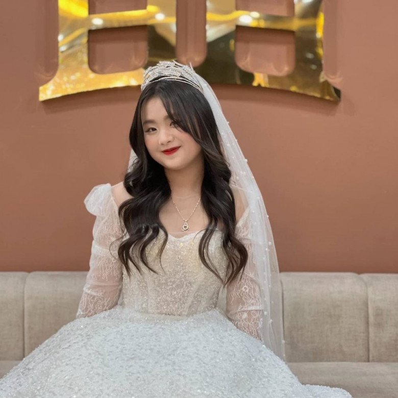 Cô nhóc cũng được trang điểm kỹ càng và tạo kiểu tóc xoăn cầu kỳ. Điểm xuyết thêm chiếc vương miện quý phái.