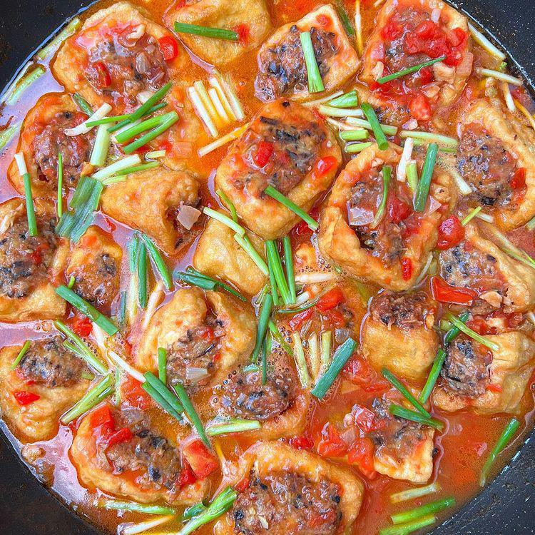 Đậu hũ sau khi chiên và tiến hành nhồi nhân như thịt nạc, nấm mèo, hành và các gia vị lại được cô chiên lần nữa và sốt cà chua cho thêm phần đậm đà, bắt mắt.