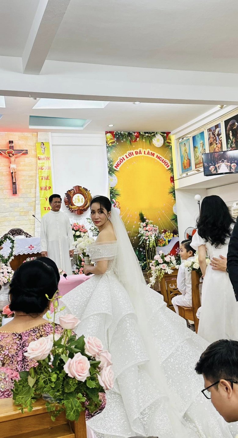 Khánh Thi diện chiếc đầm cưới khủng, phải nhờ đến 5 người xách giúp mới di chuyển được trong 1 con hẻm nhỏ.