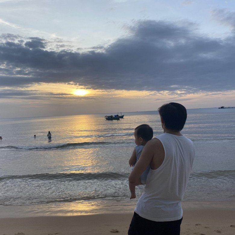 Quý Bình ẵm con trai ra ngắm biển, anh đăng bức ảnh kèm status: Chiều nay có 2 người đàn ông đi biển!.