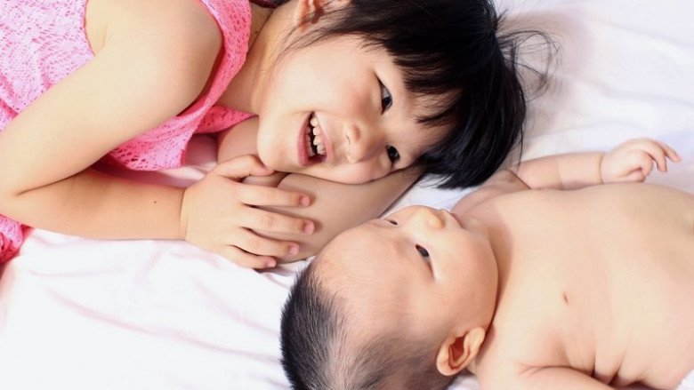 Tiểu My giả vờ quan tâm em trai để bố mẹ chú ý đến mình (Ảnh minh hoạ).