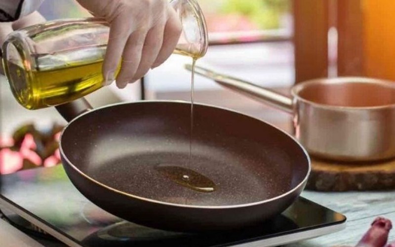 Cho một chút dầu ăn vào chảo đun nóng sau đó đổ dầu ăn đó ra, thêm dầu ăn mới vào (dầu này phải nguội). 

