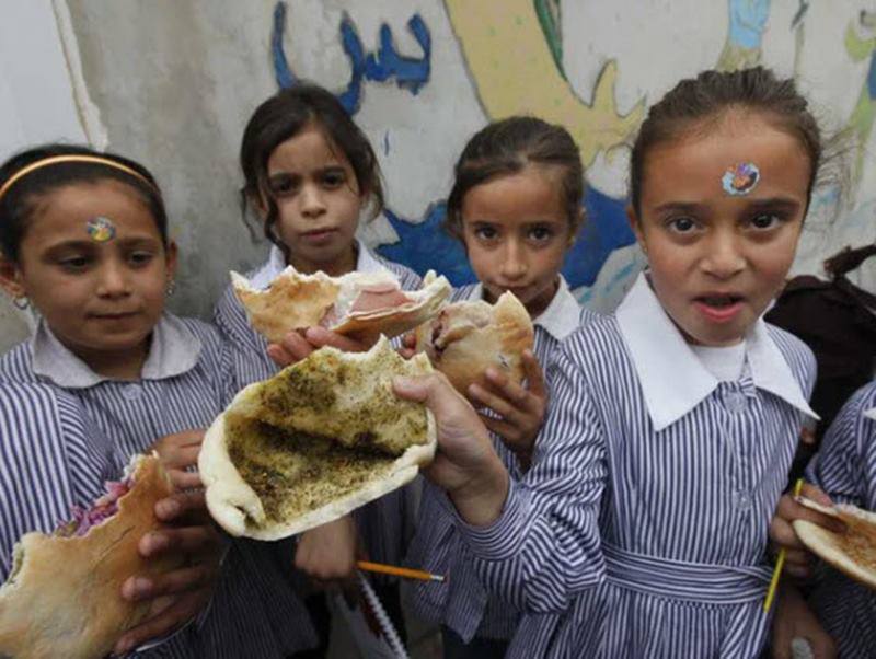 Các em học sinh ở Nablus, Bờ Tây đang ăn trưa bằng bánh mì pita nhồi dầu ô liu và za'atar, hỗn hợp các loại thảo mộc và gia vị. Nguồn: Insider, BuzzFeed
