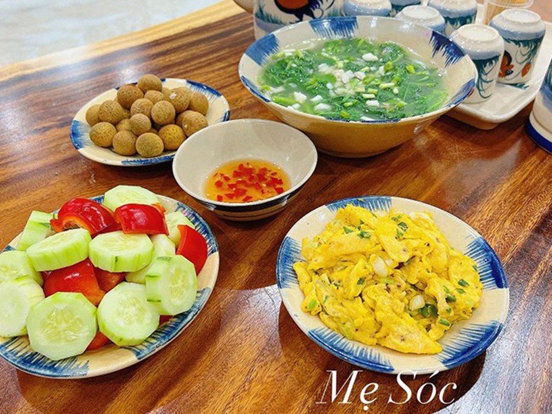 Mâm này chị Sáu có trứng rán, canh rau, salad dưa chuột.
