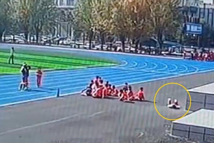 Cô bé Duo Duo (chỗ khoanh tròn) bất ngờ ngã lăn ra đất bất tỉnh sau khi chạy nước rút 50m.