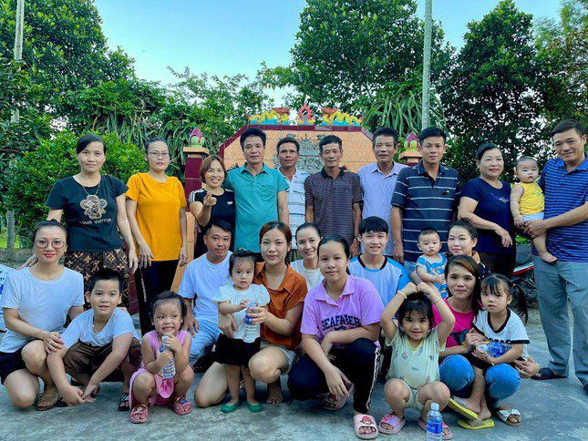 Đại gia đình ông Phong bên phần mộ của cha mẹ ở quê