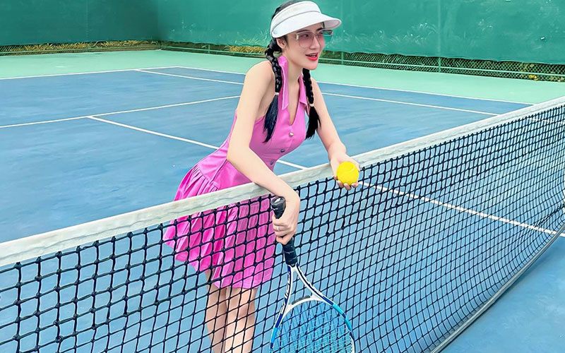 Nghi Văn đi chơi thể thao vẫn lên đồ điệu đà với váy hồng mộng mơ, đầu đội nón chuyên dụng để tránh nắng. 
