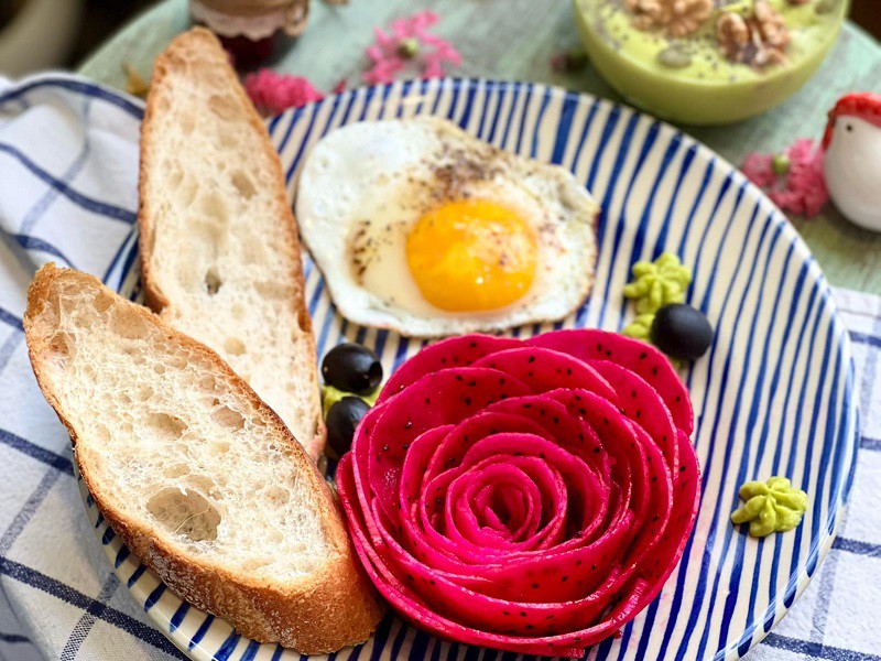 Bữa sáng với sinh tố bơ chuối và các loại hạt dinh dưỡng. Bánh mì và trứng ốp la. Thanh long được biến hình điệu đà thành bông hoa hồng. Đây là cách chị Trang khởi đầu một ngày mới. 
