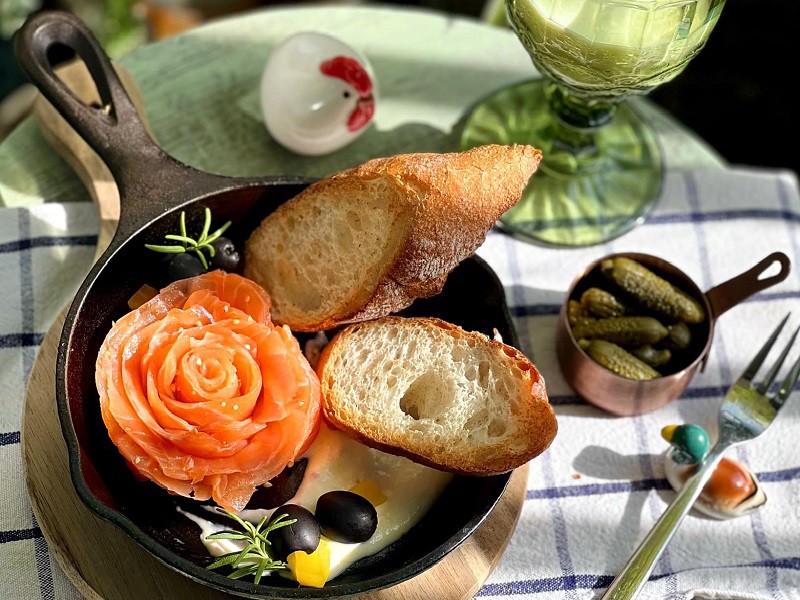 Một bữa sáng nhiều chất với cá hồi xông khói ăn cùng bánh mì sourdough nướng giòn và olive, dưa chuột muối.
