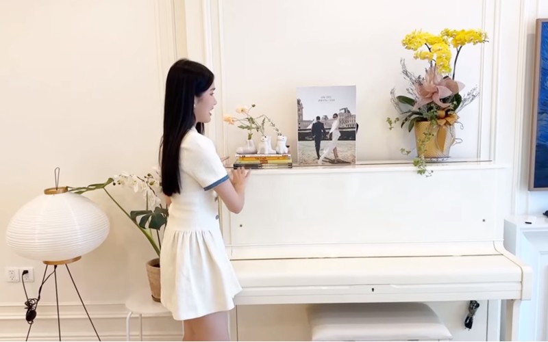 Điểm nhấn của phòng khách là cây đàn piano. Chồng cô từng đàn piano tặng vợ trong đám cưới. Bên trên cây đàn là album ảnh cưới của hai vợ chồng, 3 con mèo decor có thể cắm hoa, giỏ hoa và sách.
