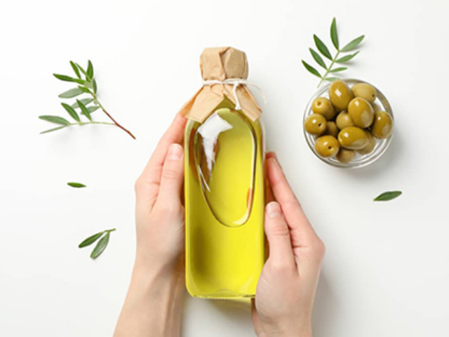 A bottle of olive oil and a spoon