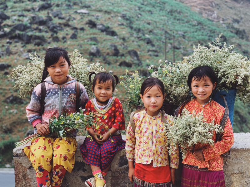 Bạn sẽ bắt gặp những cô bé dân tộc cùng gùi hoa xinh xắn dọc đường đi.
