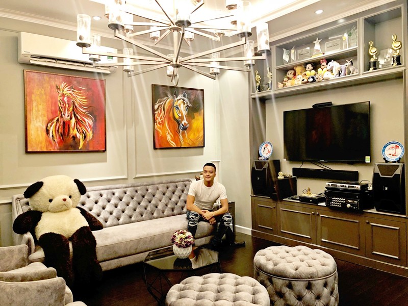 Phòng khách có bộ sofa êm ái. Nơi đây, Cao Thái Sơn có tủ trưng bày với nhiều kỷ niệm chương, thú bông gắn với những dấu ấn làm nghề của mình.
