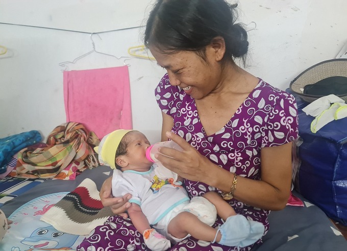 Chị Y Chánh bên cạnh con trai tại gác trọ gần Bệnh viện Ung Bướu TP HCM. Ảnh: Lê Phương