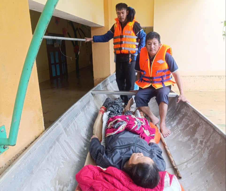 Lực lượng chức năng xã An Thủy dùng ghe nhôm đưa bà Lâm vượt lũ đến bệnh viện cấp cứu. Ảnh: Lê Văn Quyết.