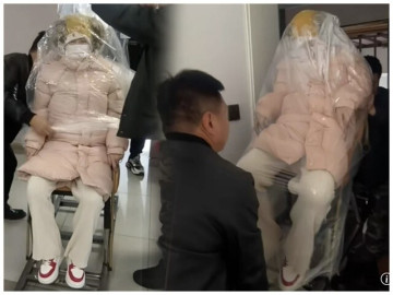 Sản phụ trùm kín người bằng nilon sau khi sinh con để tránh gió