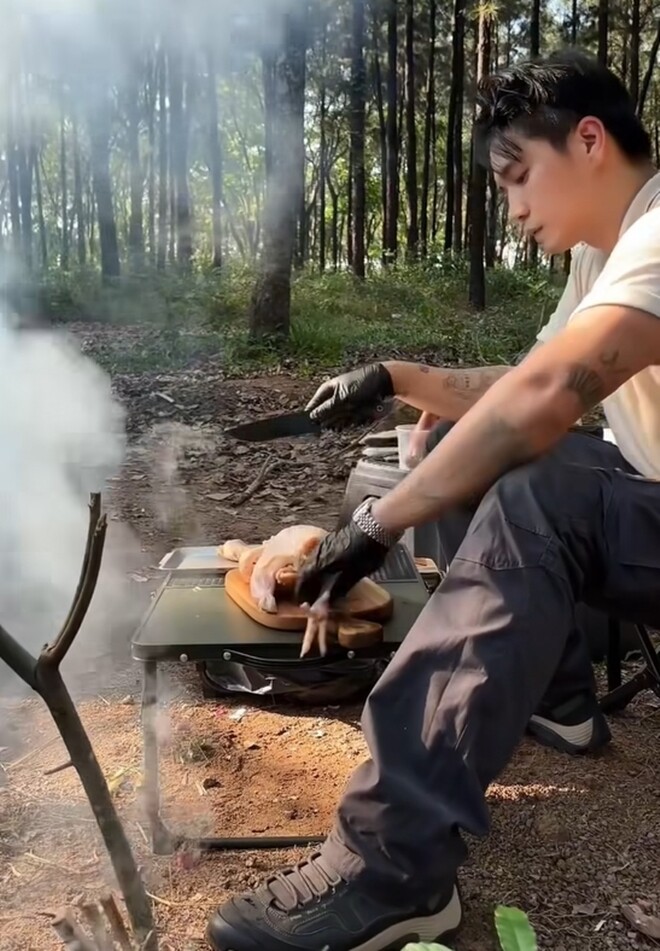 Chàng CEO xử lý gà bên bếp lửa, anh chặt riêng phần đầu và chân gà, để nguyên phần giữa. Dáng ngồi tập trung và bàn tay khéo léo chứng tỏ sự chuyên nghiệp của một người đầu bếp. 