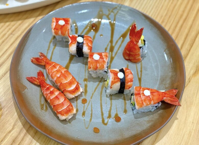 Sushi tôm được trình bày khéo léo, điểm thêm những lát tôm đỏ mọng, chút nước sốt nhỏ giọt trên đĩa, làm nên một tổng thể hài hòa và đầy màu sắc. Đan Lê cho biết đây là màu tôm nguyên bản: Tôm sú biển tươi nên màu đỏ đậm đẹp lắm.