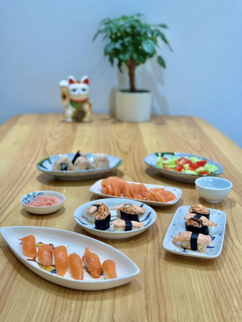 Đĩa sushi được trình bày đẹp mắt với các loại sushi nướng và cá hồi tươi. Một bữa ăn với nhiều loại sushi và sashimi được sắp xếp gọn gàng, kết hợp với những món ăn phụ nhẹ nhàng.