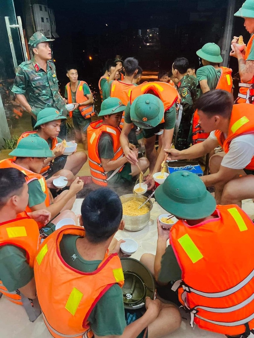 Những người lính tranh thủ ăn uống để còn tiếp tục cứu trợ