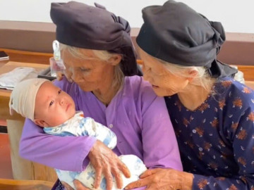 Ấm áp khoảnh khắc 2 cụ bà bán rau ôm em bé trong lòng, cử chỉ đẹp của người cha mới thực sự cảm động
