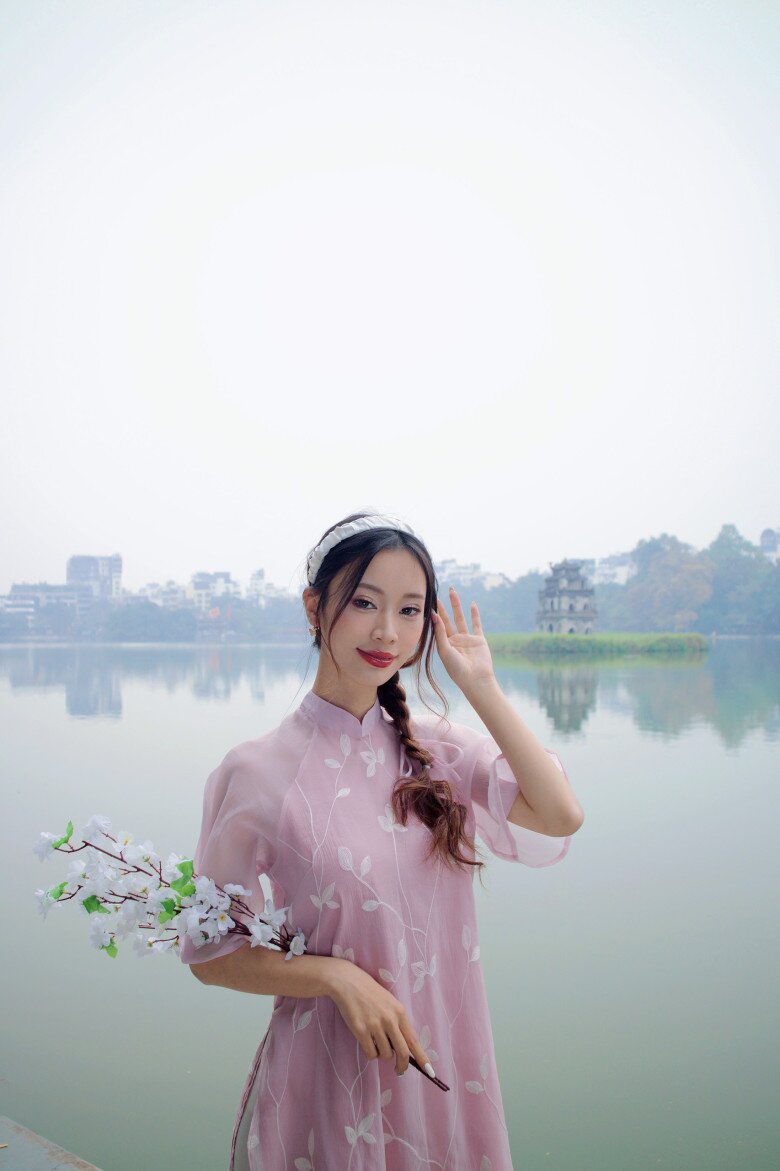 Không cần phụ kiện cầu kỳ, chỉ cần một cành hoa nhỏ cùng tà áo thướt tha bạn cũng đủ tạo thành bức ảnh đẹp. 