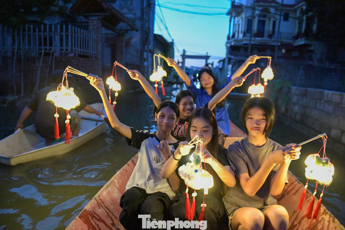 Ánh đèn lồng hắt xuống mặt nước lấp loáng, tiếng cười trẻ thơ vang lên giữa vùng quê vẫn chìm trong lũ. tạo nên khoảnh khắc xúc động về sự sẻ chia.