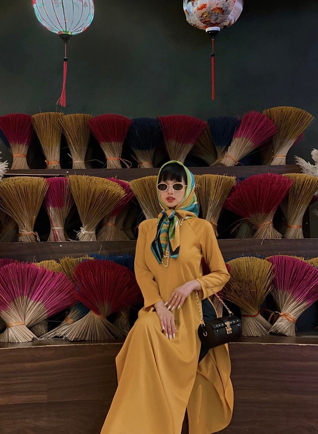 ... Lúc lại nổi bật với áo dài màu vàng đậm.