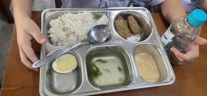 Khay cơm khác là nửa quả trứng luộc, ít lát chả và thức ăn khô giống muối mè