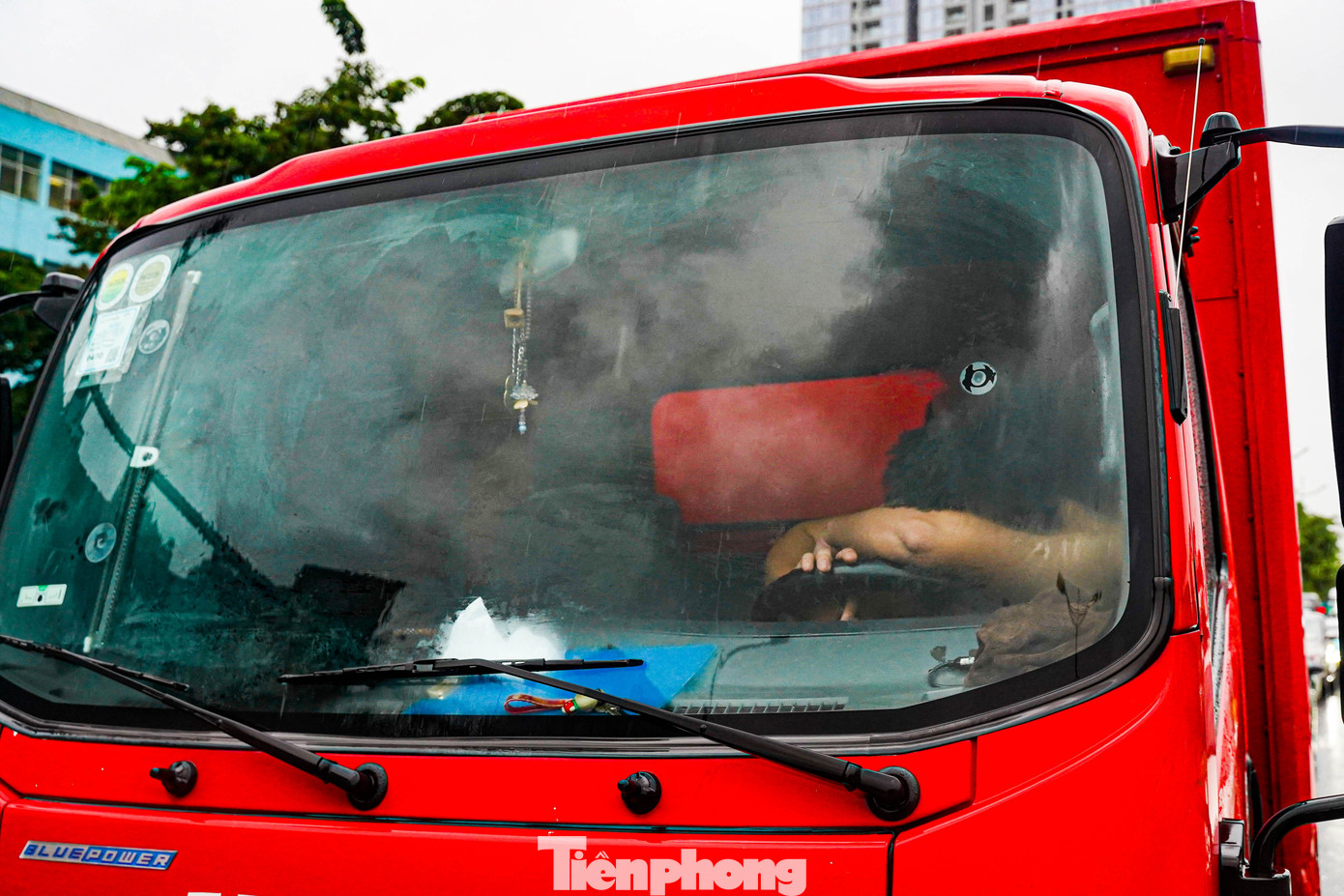 Xe xếp hàng dài bất động vì phía trước ngập sâu và tắc đường, một tài xế mệt mỏi gục đầu xuống vô-lăng chợp mắt trong lúc chờ đợi.