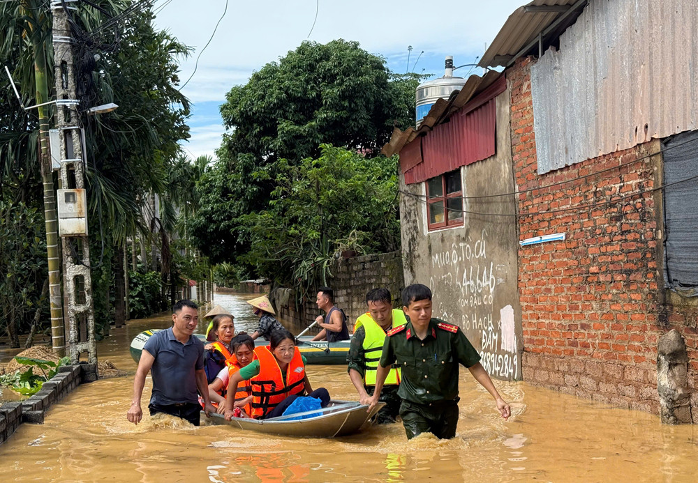 Công an xã Mỹ Thái hỗ trợ đưa người dân ra khỏi khu ngập lụt.