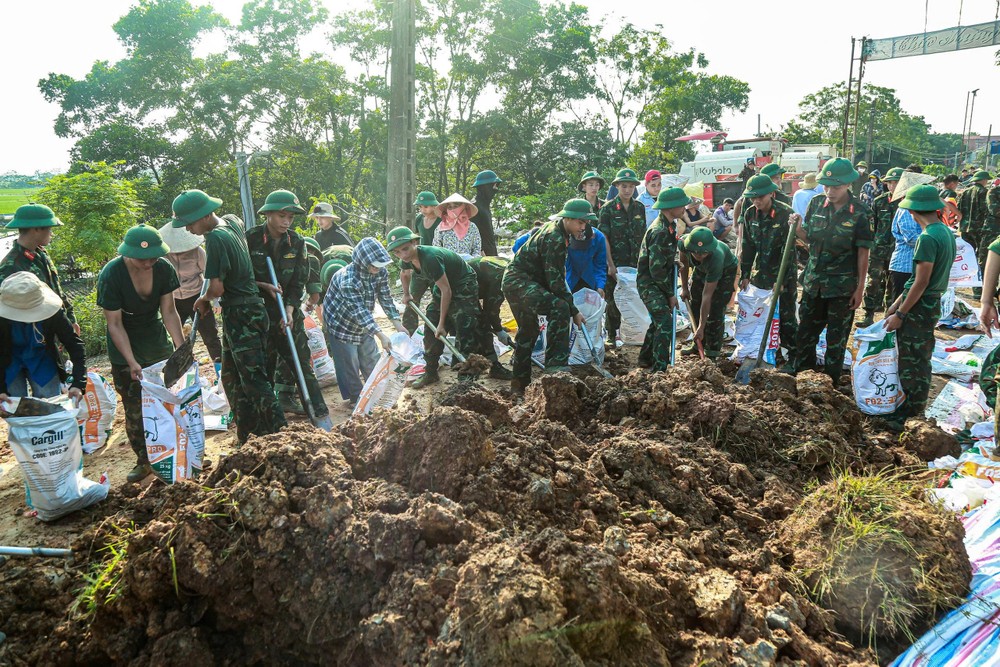 Các lực lượng chức năng cùng người dân đắp đất chống lũ tràn nhiều vị trí đê thấp với chiều dài hơn 5km.
