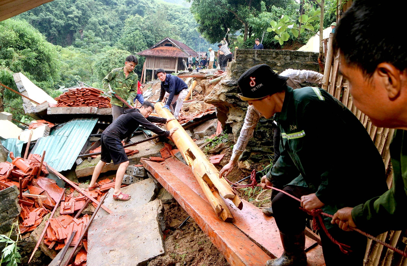 Những cây cột nhà lớn được các lực lượng kéo ra khỏi hiện trường.