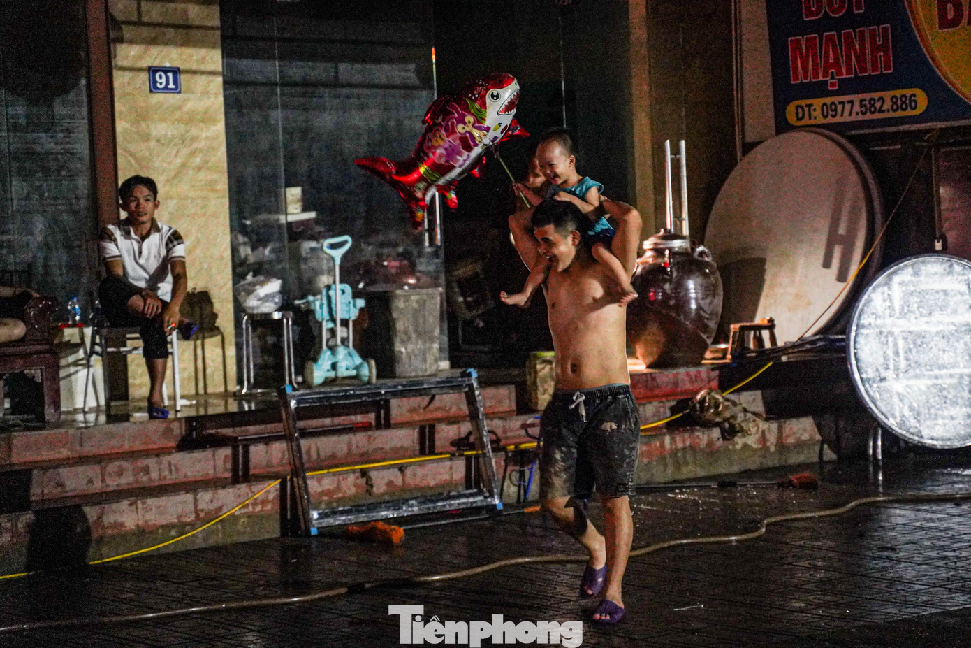 Trong đêm tối vì mất điện, người bố cố gắng vui chơi với con cho quên bớt nóng nực và khó chịu.